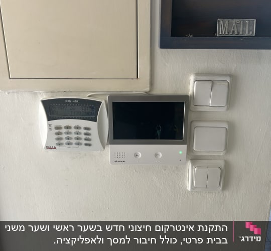 מערכת אינטרקום ולוח מקשים על קיר לבן
